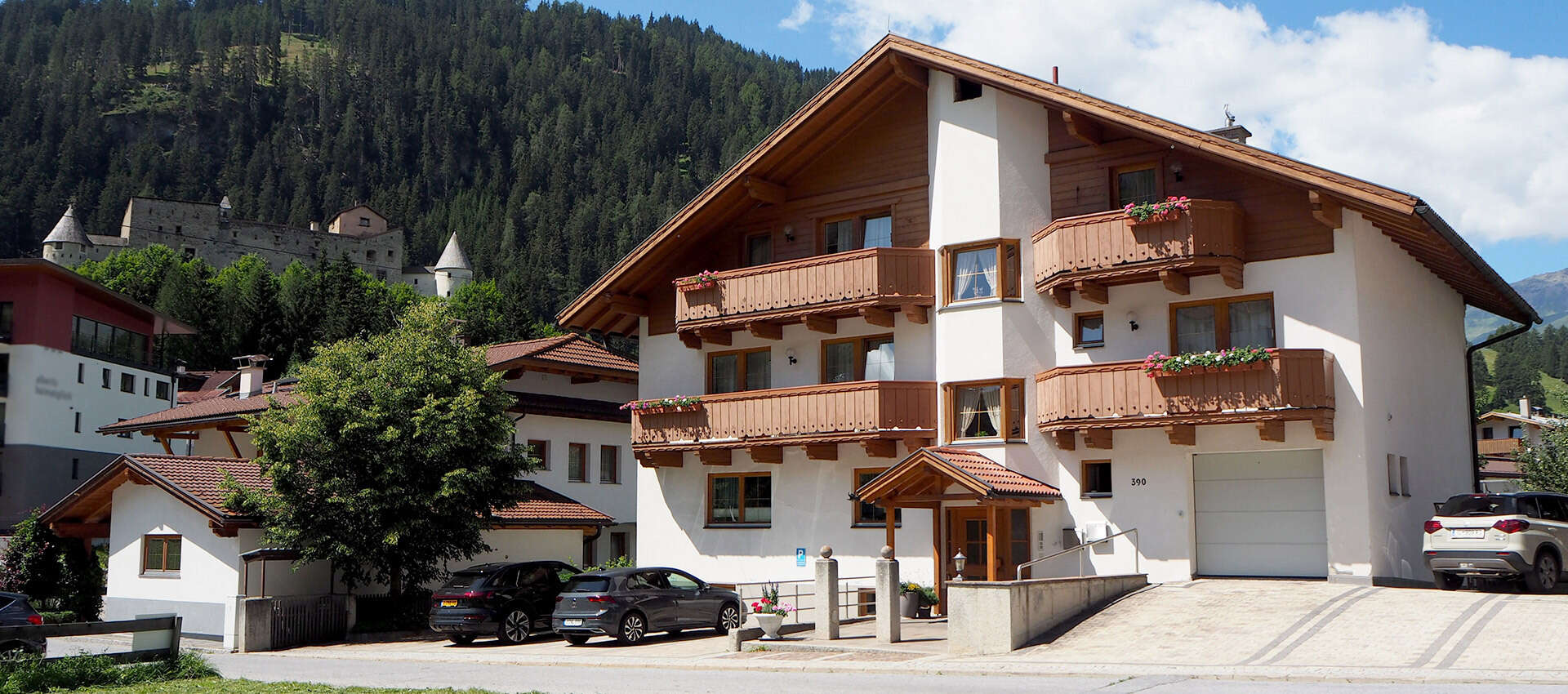 Valdafur Suites Haus im Sommer mit Schloss Naudersberg im Hintergrund